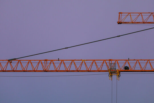 Intersection of Crane Booms on Purple Skies