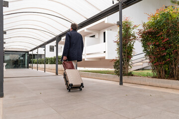 Businessman arriving in hotel with suitcase and bag