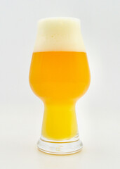 A closeup of a glass of hazy pale ale isolated against a white background. 