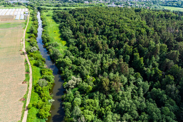 Naklejka premium Aerial view of forest area adjacent to river