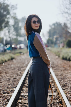 Woman standing on railway track in sunlight