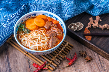 A bowl of traditional Chinese food braised beef noodles on a tray