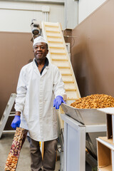 Smiling warehouse worker packaging almonds during shift, vertical photo