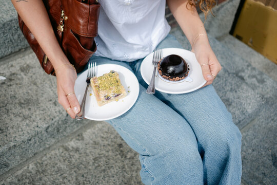 anonymous Young woman enjoying bakery goods in the street in Boston 