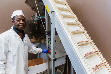 Warehouse worker next to conveyor belt with pistachios ready for packaging