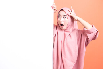 Shocked Muslim Woman Displaying a Blank Sign with a Surprised Ex