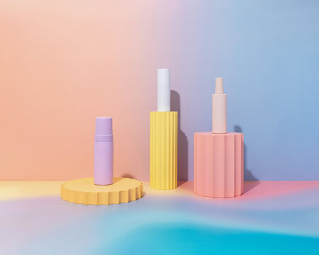 Mockup of empty pastel gradient product bottles on colorful background