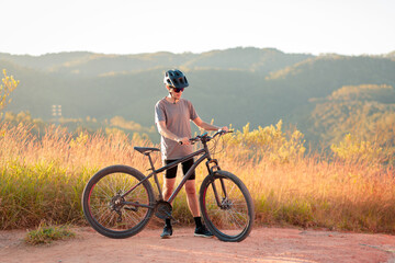 Cyclist taking a quiet moment with his bike on a dirt trail. Outdoor activity promoting...