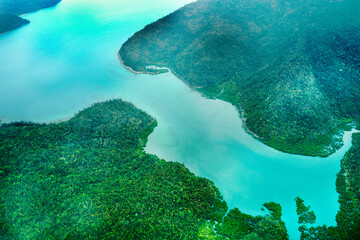 Aerial view of submerged reefs (green color) and surface clear waters (blue color) at Great Barrier Reef, the world's largest coral reef system in the Coral Sea near Whitsunday Island. Australia. 2020