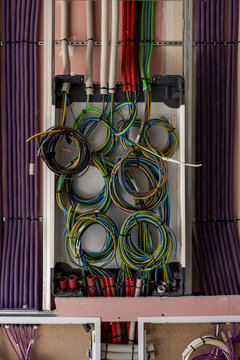 Inside of an home electricity breaker box with many colorful wires