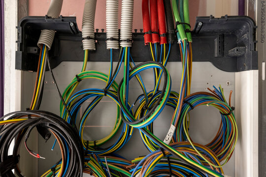 Inside of an home electricity breaker box with many colorful wires