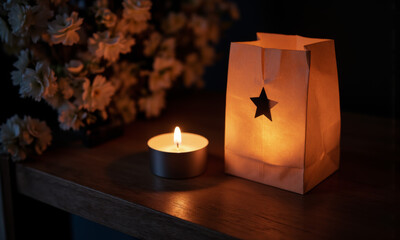 A Paper Bag Luminaria with a Star Cut Out, a Candle Glowing from Within