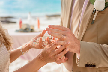 Newlyweds exchange rings, groom puts the ring on the bride's hand.