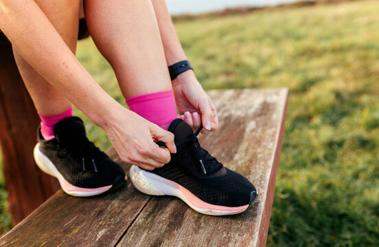 Close-up of hands tying running shoes outdoors