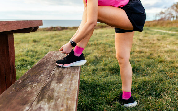 Close-up of hands tying running shoes outdoors