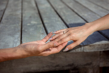 Man and woman, newlyweds holding hands with blurred background.