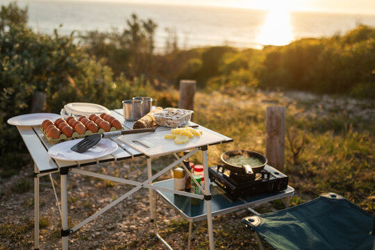 Outdoor Camping Dinner Setup by the Beach at Sunset in Portugal