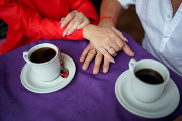 Man and woman, newlyweds holding hands with blurred background.