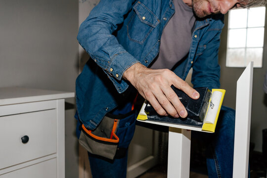 Man Sanding Wooden Surface During Home Renovation