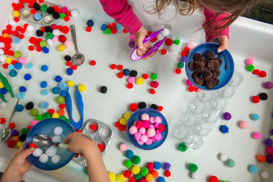 Anonymous kids play and learn with a sensory table in a preschool