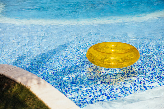 Yellow inflatable ring floating in the swimming pool