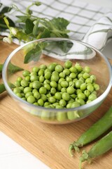 Fresh ripe green peas on white wooden table, closeup