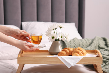 Woman having delicious breakfast in bed, closeup