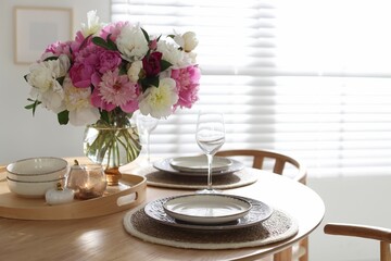 Beautiful table setting with bouquet of peonies in dining room. Space for text