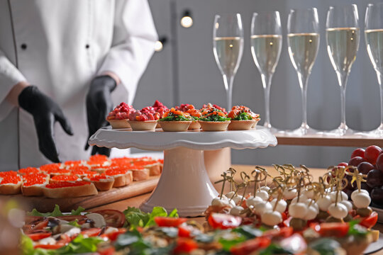 Chef arranging appetizers on buffet table, selective focus