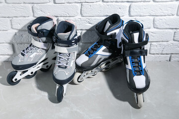Roller skates on grey marble table near white brick wall, above view