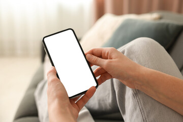 Woman using modern smartphone on sofa at home, closeup