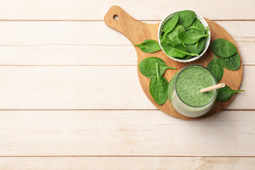 Tasty smoothie and spinach leaves on white wooden, flat lay. Space for text
