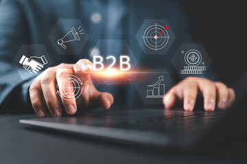 B2B marketing concept, business to business, e-commerce, Businessman using laptop and touching to B2B icons for collaboration and partnership.