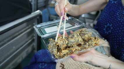 あおさの天ぷらを食べる女性