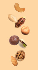 Peanut and other nuts falling on beige background