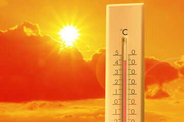 Extremely high temperature on thermometer against orange sky on sunny day. Severely hot summer...