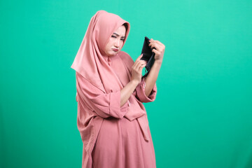 Disappointed woman showing her empty wallet, with a sad face exp
