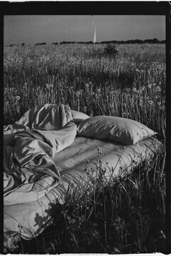 Cozy bedding set on a grassy field under soft sunlight