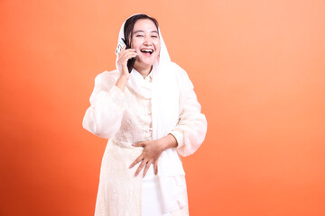 Joyful Muslim Woman Chatting on Phone: A Portrait of Modern Communication and Cultural Expression,...