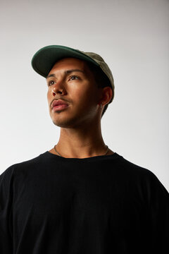 Man in a cap and black shirt on a plain background