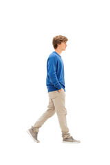 Fototapeta premium A young man confidently walks towards the camera in a casual blue sweater and beige pants. set against a clean white background. perfect for lifestyle or fashion themes