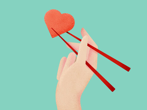 A human hand  holding a red heart-shaped food