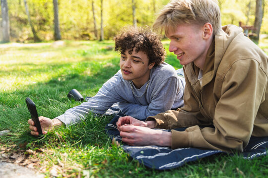 Two Young Friends Sharing Content on a Mobile Phone Outdoors