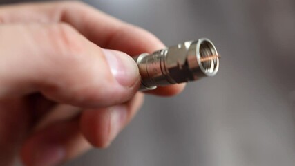Technician handling a coaxial copper cable, trimming the inner copper core