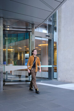City Worker Exiting Modern Glass Building in Melbourne