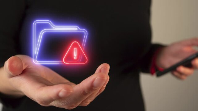 Person's hand holding a virtual folder icon with a warning sign
