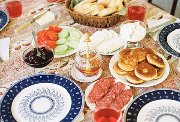 Georgian breakfast spread with bread, meats, fruits, and vegetables 