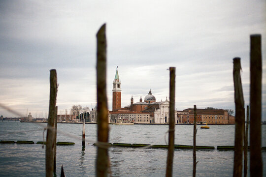 San Giorgio Maggiore island behind wooden docking poles In Venice