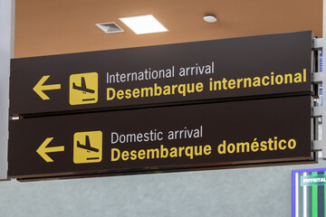 Airport information board indicating international arrivals and domestic arrivals in English and...
