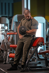 male athlete demonstrates strength and focus while performing bicep curl with dumbbell in modern...